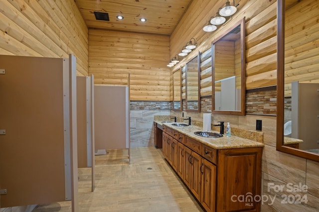 bathroom featuring wooden ceiling, hardwood / wood-style flooring, rustic walls, a towering ceiling, and vanity