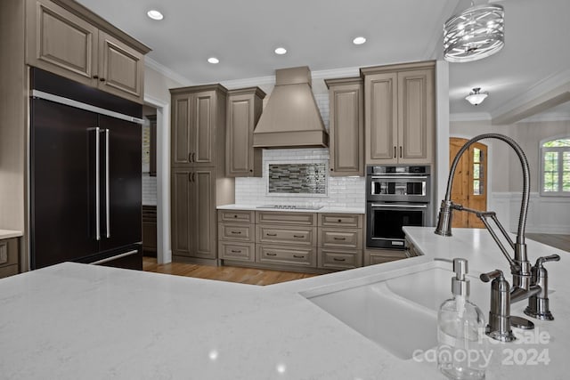 kitchen featuring custom range hood, built in refrigerator, crown molding, double oven, and black electric stovetop