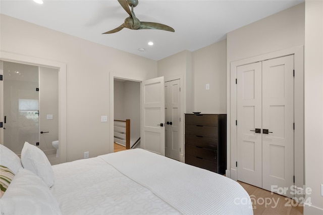 bedroom featuring connected bathroom, ceiling fan, multiple closets, and light hardwood / wood-style floors