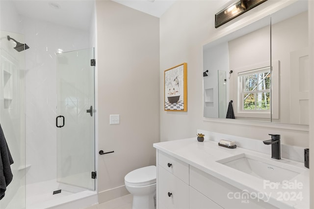 bathroom featuring vanity, toilet, and a shower with shower door