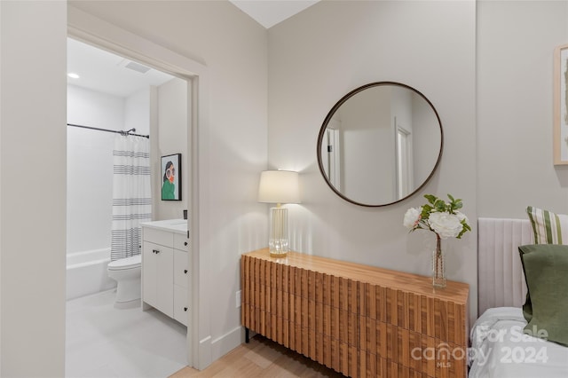 full bathroom with toilet, shower / bath combo with shower curtain, vanity, and hardwood / wood-style flooring