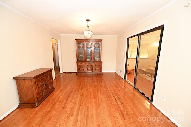 unfurnished dining area with crown molding and hardwood / wood-style flooring