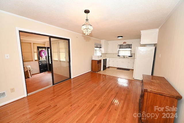 unfurnished living room with a chandelier, sink, crown molding, and light wood-type flooring