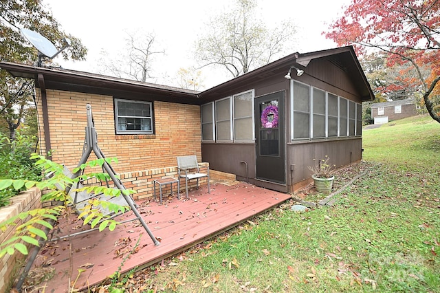 rear view of property featuring a deck and a lawn