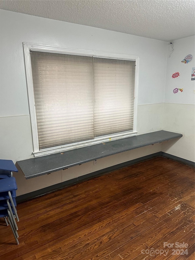 unfurnished room featuring a textured ceiling and dark hardwood / wood-style floors