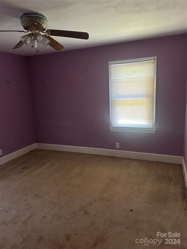 carpeted spare room featuring ceiling fan