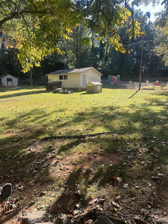 view of yard featuring a playground and a storage shed