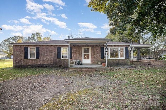 view of front of house featuring a patio area, crawl space, and brick siding