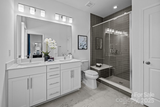 bathroom with toilet, vanity, and a shower with door