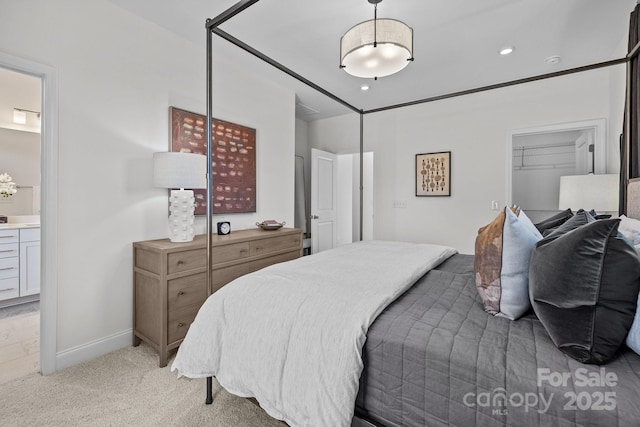 bedroom featuring light carpet and ensuite bath