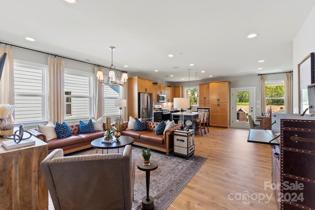 living room featuring a chandelier and light hardwood / wood-style flooring