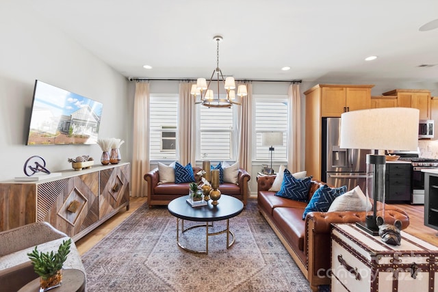 living room featuring an inviting chandelier and light wood-type flooring