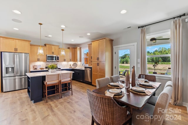 dining room with sink, ceiling fan, and light hardwood / wood-style flooring