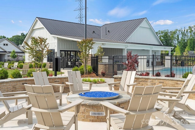 exterior space featuring an outdoor fire pit and a fenced in pool