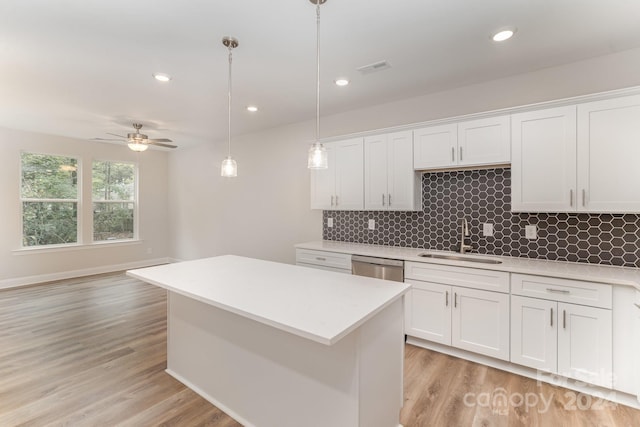 kitchen featuring ceiling fan, white cabinetry, sink, and hanging light fixtures