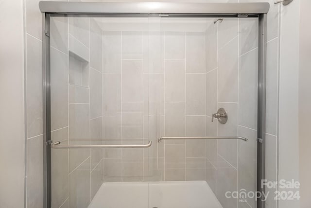 bathroom featuring a shower with door