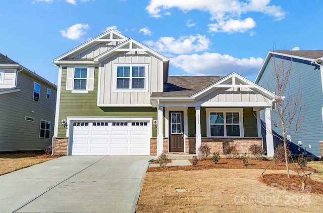 craftsman-style home with a garage, stone siding, board and batten siding, and driveway