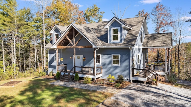 cape cod home featuring covered porch and a front lawn