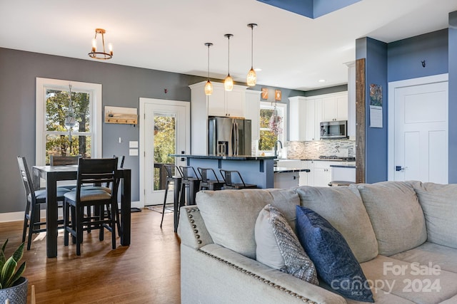 living room featuring sink, dark wood-type flooring, and a wealth of natural light