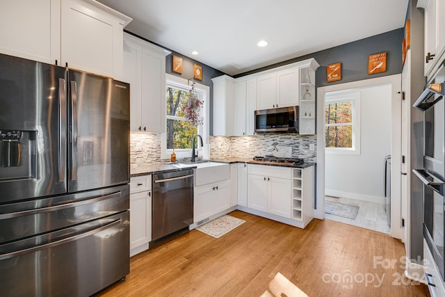 kitchen featuring white cabinetry, stainless steel appliances, light wood-type flooring, and plenty of natural light