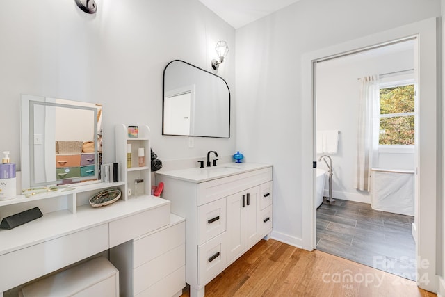 bathroom with vanity, hardwood / wood-style floors, and a bathing tub