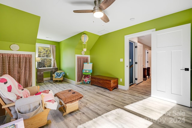 living area with lofted ceiling, light hardwood / wood-style flooring, and ceiling fan