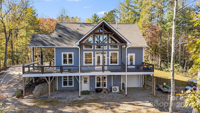 back of house featuring a garage and a deck