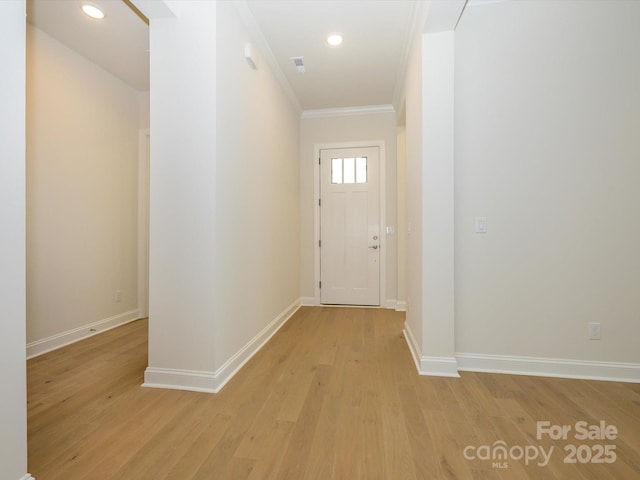 doorway to outside with ornamental molding and light hardwood / wood-style floors