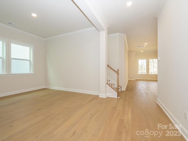 spare room featuring ornamental molding and light hardwood / wood-style flooring