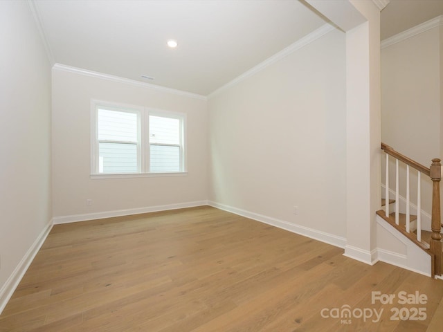 spare room with crown molding and light wood-type flooring