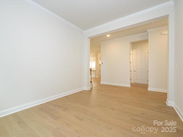 spare room with ornamental molding and light wood-type flooring