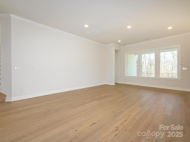 unfurnished room with ornamental molding and light wood-type flooring