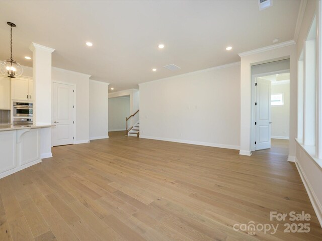 unfurnished living room with ornamental molding, a chandelier, and light wood-type flooring