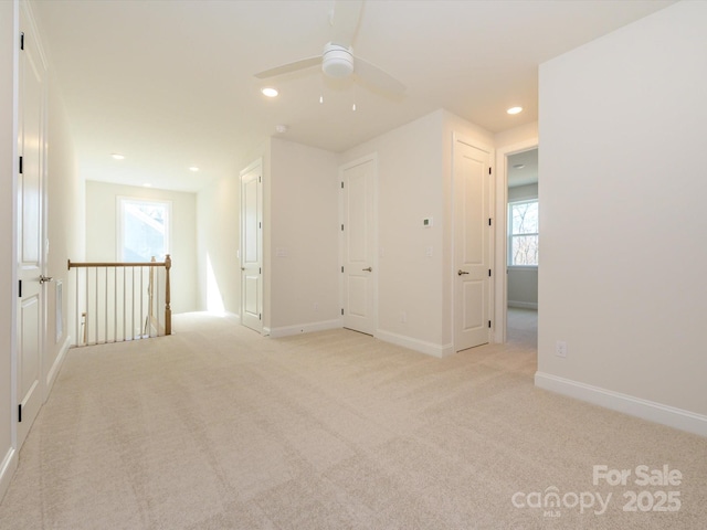 carpeted spare room featuring ceiling fan