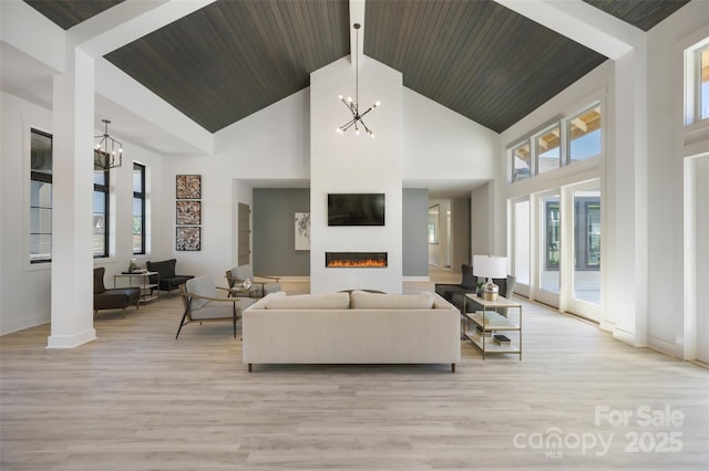 living room featuring high vaulted ceiling, a notable chandelier, a large fireplace, wooden ceiling, and light wood-type flooring