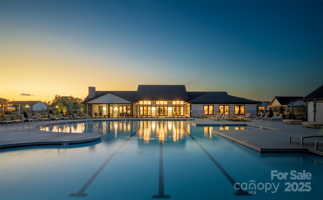 pool at dusk with a patio area