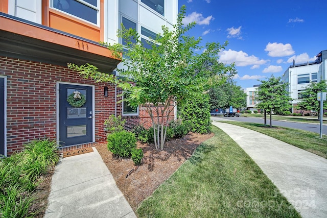 view of exterior entry with a lawn