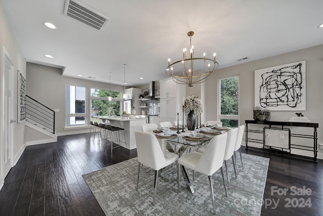 dining area featuring dark wood-type flooring and an inviting chandelier