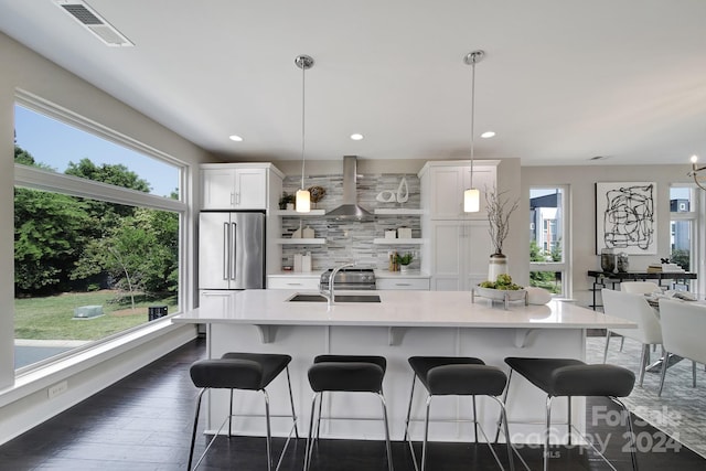 kitchen featuring high quality fridge, pendant lighting, and plenty of natural light