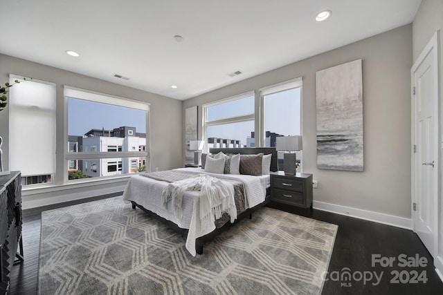 bedroom featuring multiple windows and dark wood-type flooring