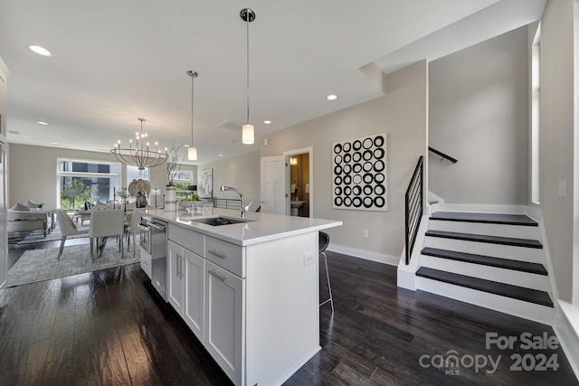 kitchen with dark hardwood / wood-style flooring, an island with sink, white cabinetry, dishwasher, and sink