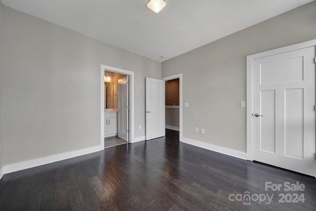 unfurnished bedroom with dark hardwood / wood-style floors and connected bathroom