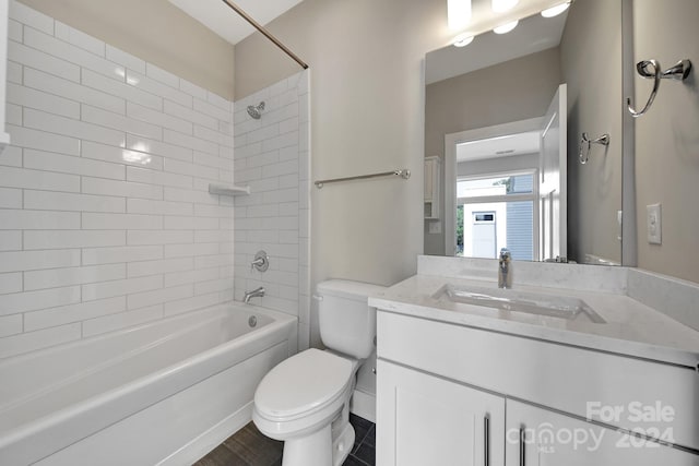 full bathroom with vanity, tiled shower / bath combo, and toilet