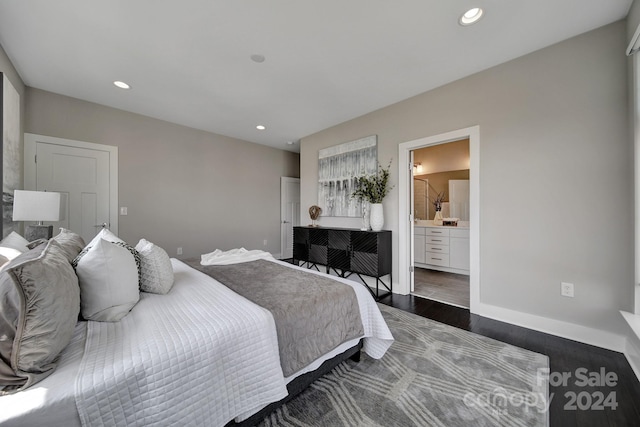 bedroom with ensuite bathroom and dark hardwood / wood-style flooring