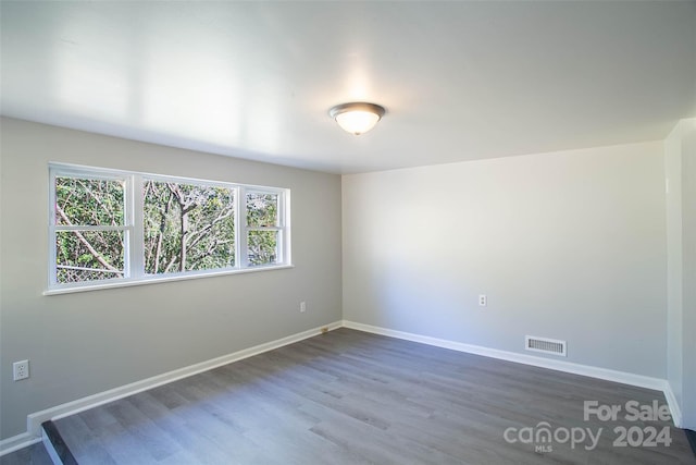 unfurnished room with dark hardwood / wood-style flooring