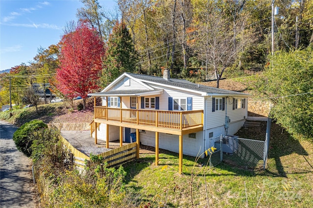 back of property with a yard and a wooden deck