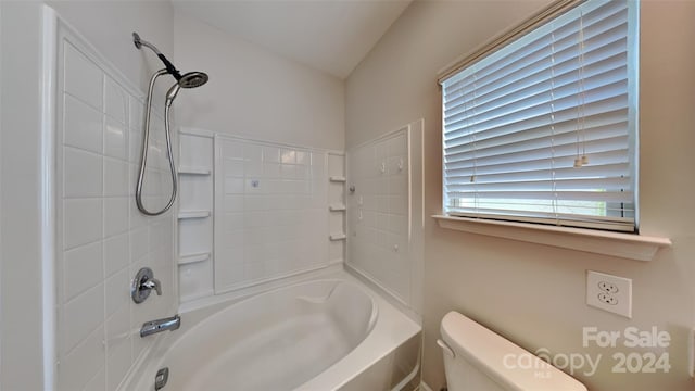 bathroom featuring tiled shower / bath combo and toilet