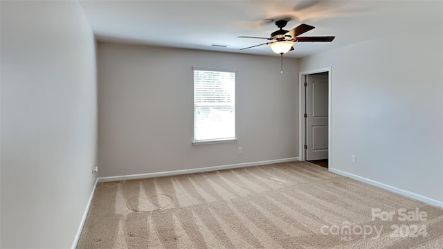 carpeted spare room with ceiling fan