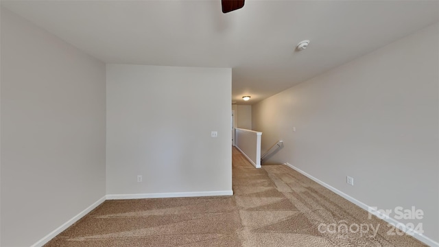 unfurnished room with light colored carpet and ceiling fan