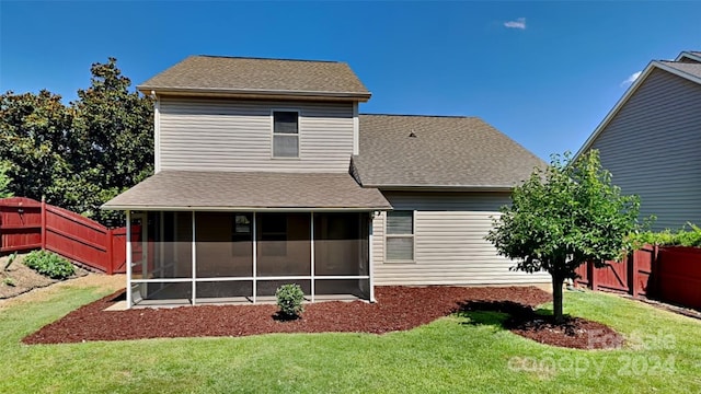 rear view of house with a lawn and a sunroom